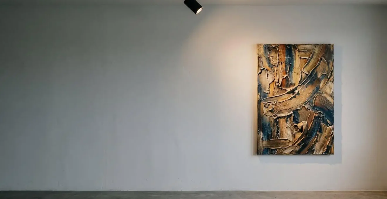 Vue de côté d'un tableau texturé sur toile éclairé par un spot LED positionné latéralement, créant des ombres portées qui sculptent les reliefs
