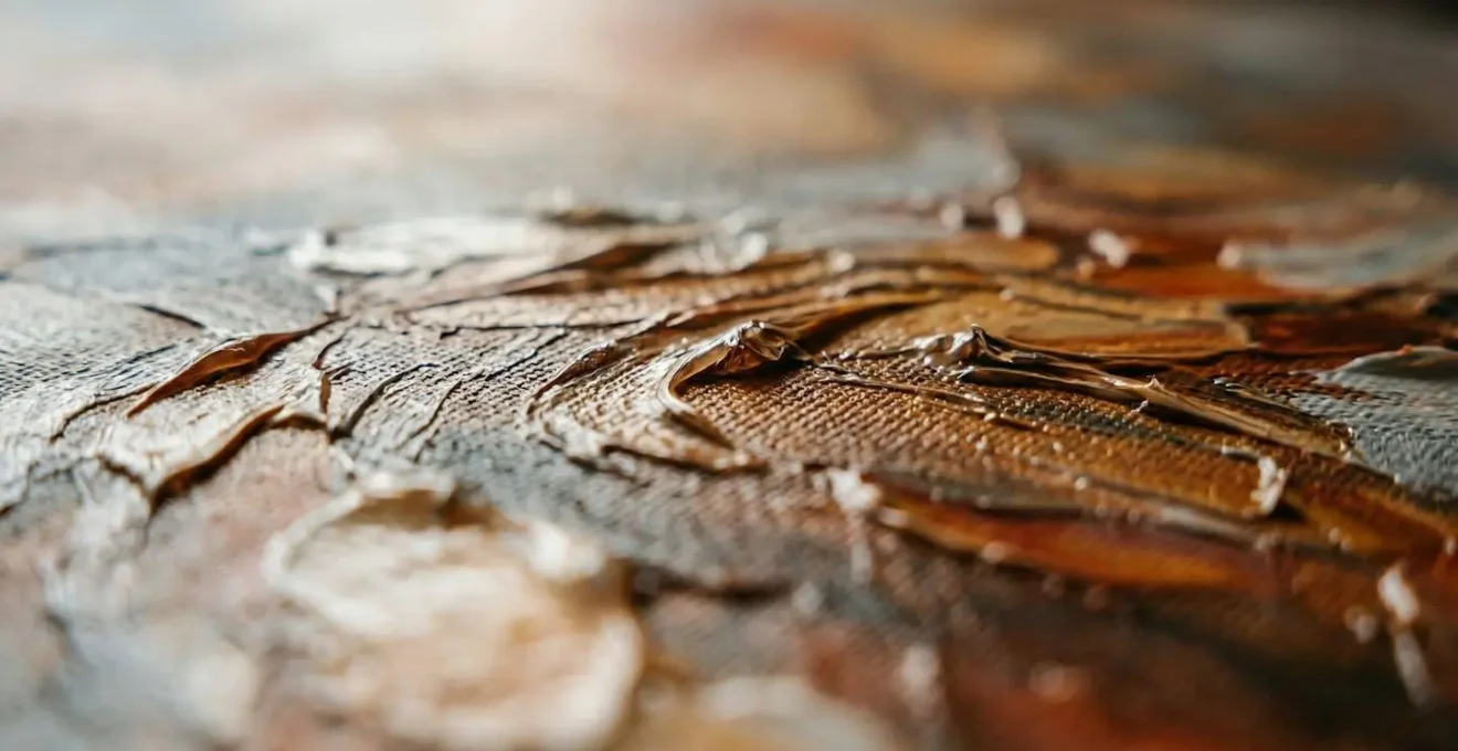 Gros plan d'une impression sur toile avec texture en relief imitant les coups de pinceau d'une peinture à l'huile, éclairée par une lumière rasante