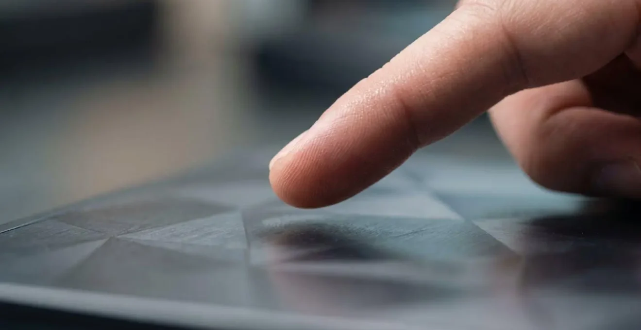 Gros plan sur une main interagissant avec une surface tactile ergonomique montrant les proportions et l'accessibilité