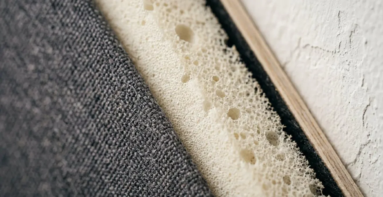 Detail macro d'un panneau acoustique sur chassis montrant l'espace d'air entre la mousse absorbante et le mur